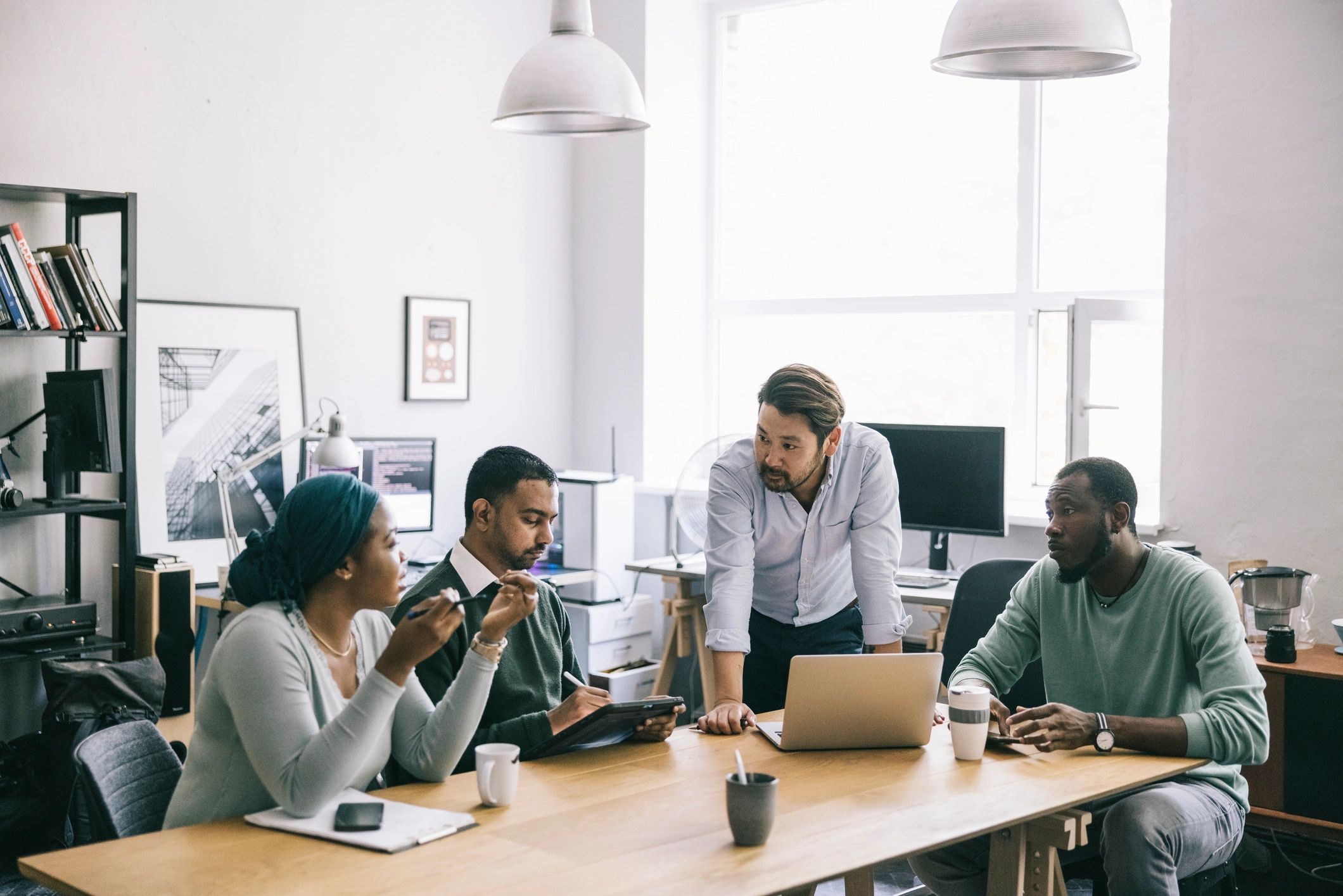 Team meeting around a laptop in an office